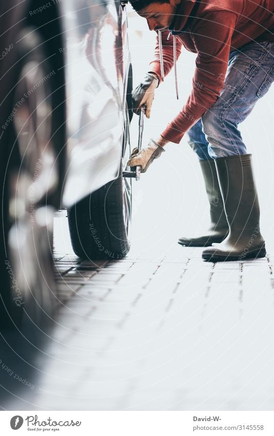 Mann wechselt Reifen am Auto Autoreifen reifenwechsel Selbstständigkeit Wagenräder abziehen Sicherheit selbst selbstgemacht Frühling Radwechsel sommerreifen