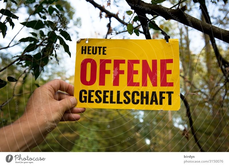 Eine Hand hält ein Schild mit der Aufschrift " Heute Offene Gesellschaft " in die Höhe Mensch Leben Himmel Wald Schriftzeichen Hinweisschild Warnschild