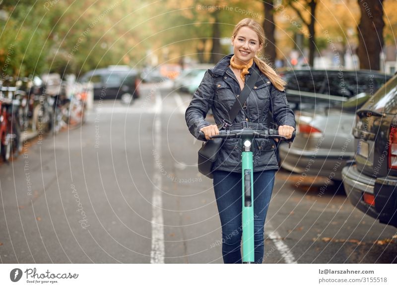 Junge glückliche Frau auf einem Elektroroller in der Stadt Lifestyle Glück Freizeit & Hobby Technik & Technologie Erwachsene 1 Mensch 18-30 Jahre Jugendliche