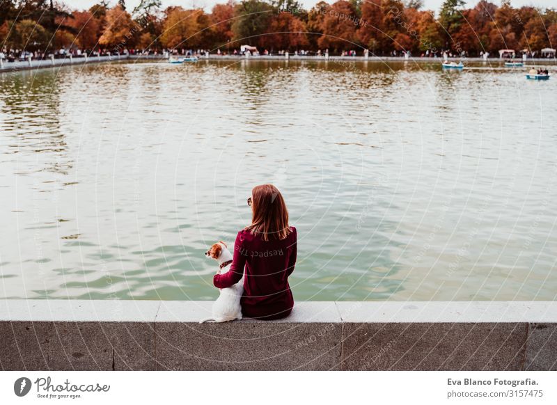 junge Frau und süßer Hund am See in einem städtischen Park. Konzept der Liebe zu Tieren. Retiro-Park Madrid Haustier Außenaufnahme Großstadt Umarmen