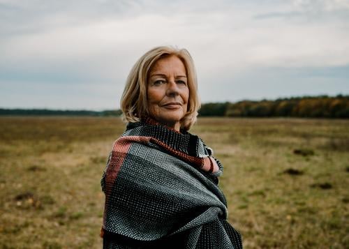 60 jährige Dame mit Schal in Herbstlandschaft Stil Weiblicher Senior Frau 60 und älter Natur Landschaft Wolken Wiese Mantel Tuch blond Blick elegant Gesundheit