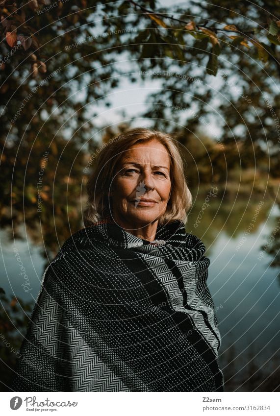 TRAUDL Lifestyle elegant Stil Frau Erwachsene Weiblicher Senior 45-60 Jahre 60 und älter Natur Landschaft Herbst Schönes Wetter Baum Sträucher Seeufer Umhang