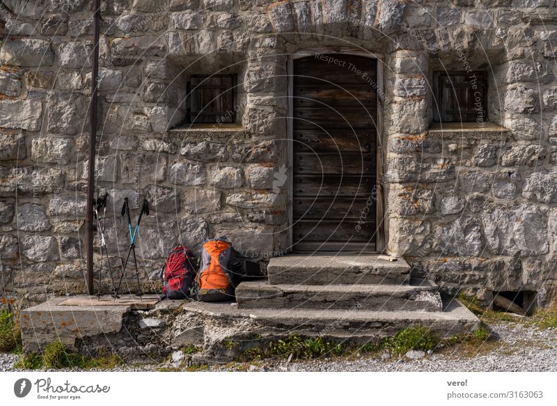 Mach mal Pause Vesper wandern Schönes Wetter Alpen Berge u. Gebirge Mauer Wand Treppe Fassade Fenster Tür Fußgänger gehen Rucksack Wanderstock Stein Bewegung