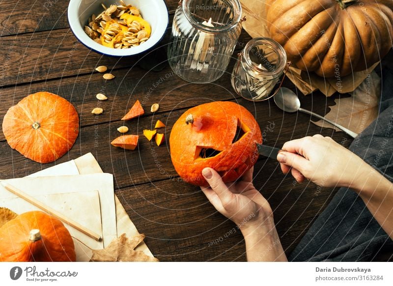 Ein Mann macht ein Gesicht aus einem Kürbis. Halloween orange heimwärts jack-o-lantern Tradition Feiertag Herbst Oktober traditionell selbstgemacht Laterne