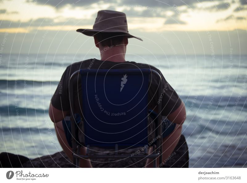 Warten auf den Sonnenaufgang. Mädchen mit großer Jacke sitzt am Meer und wartet. Freude harmonisch Sommer maskulin Familie & Verwandtschaft Rücken 1 Umwelt