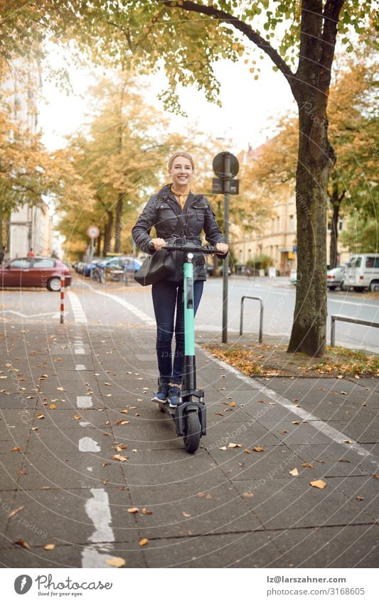 Junge glückliche Frau auf einem Elektroroller in der Stadt Lifestyle Glück Freizeit & Hobby Technik & Technologie Erwachsene 1 Mensch 18-30 Jahre Jugendliche