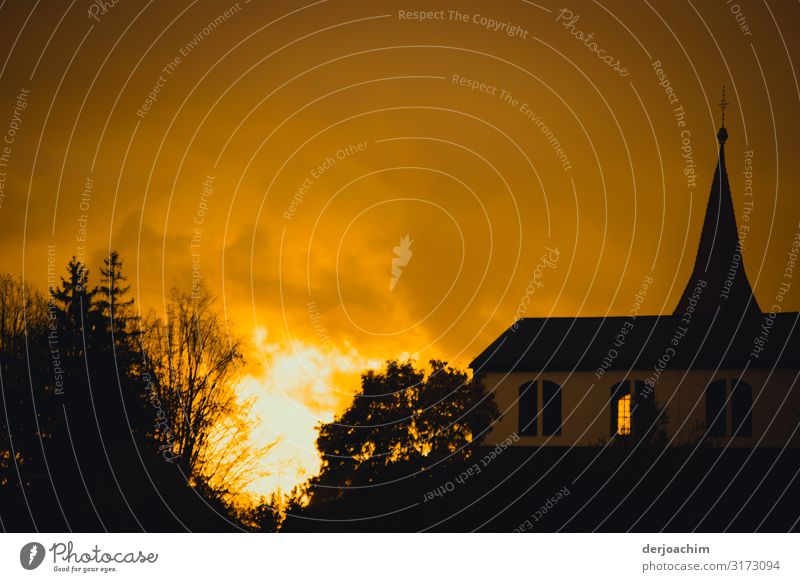 Nur ein " Sonnenuntergang " zwischen  einer Kirche und einer Baumgruppe. Es sieht aus, als würde es brennen. Freude Wohlgefühl Umwelt Sonnenaufgang Herbst