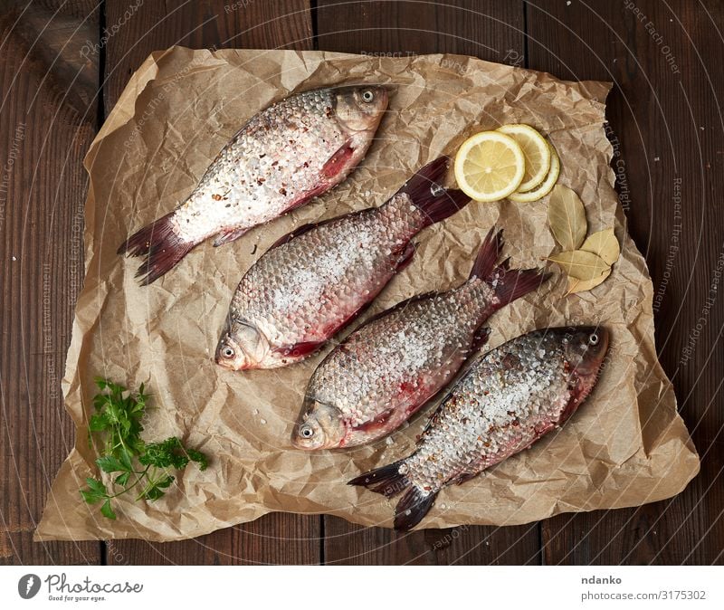 ganzer frischer Karausche mit Schuppen Fleisch Fisch Kräuter & Gewürze Ernährung Essen Abendessen Diät Tisch Küche Tier Fluss Papier Holz lecker natürlich oben