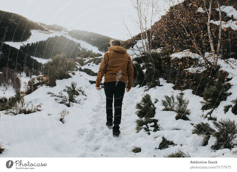 Mann, der auf einem Wanderweg in einer verschneiten Landschaft geht. laufen Schnee Fußweg Berge u. Gebirge Berghang Natur Aktion Wanderer Tag Bewegung Winter