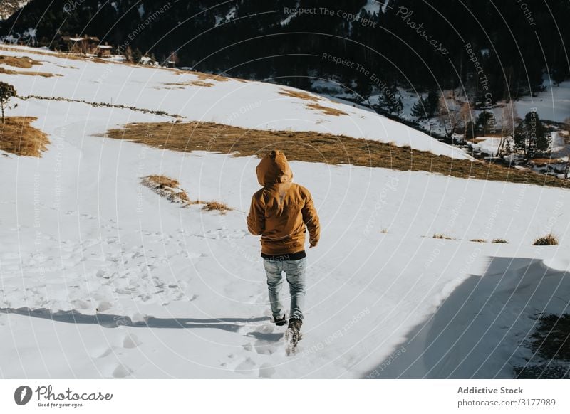 Mann, der auf einem Wanderweg in einer verschneiten Landschaft geht. laufen Motorhaube Schnee Fußweg Berge u. Gebirge Berghang Natur Aktion Wanderer Tag