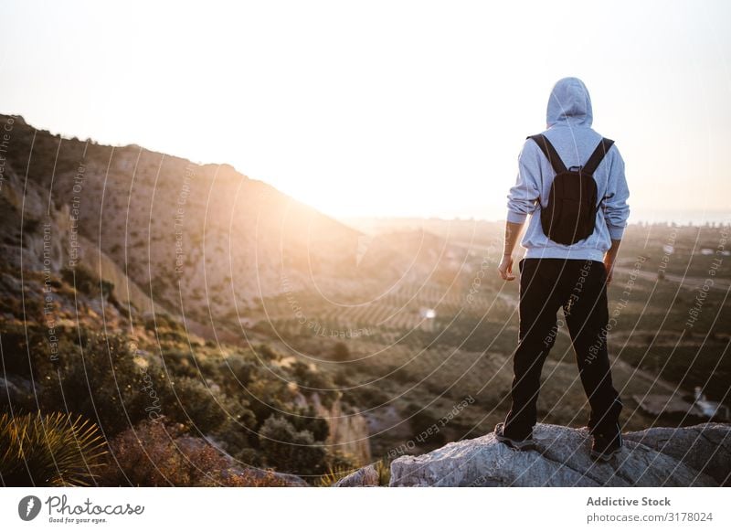 Reisender, der den Sonnenaufgang auf dem Land bewundert. Mann Wanderer Tal Morgen Landschaft Berge u. Gebirge malerisch Errungenschaft Höhe Sport anhaben stehen