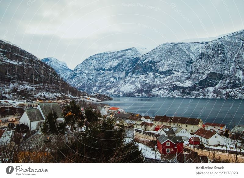 Kleine Stadt in der Nähe von Meer und schneebedeckten Bergen Berge u. Gebirge Schnee Wolken Himmel Winter Landschaft Wasser Bucht Natur Wohnsiedlung Haus Düne