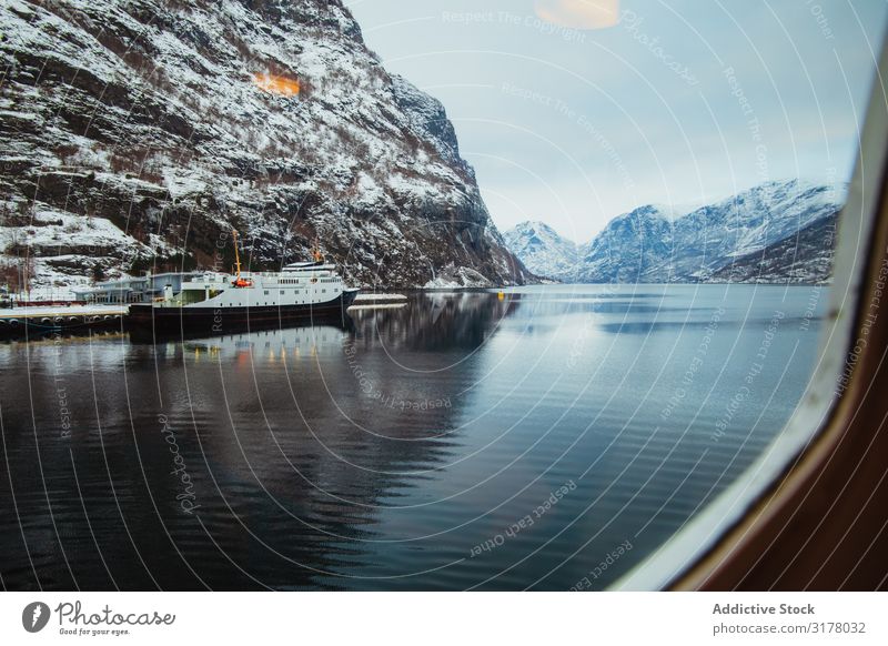 Schiffe in der Nähe von schneebedeckten Klippen Wasserfahrzeug Winter Schnee ruhig Aussicht Sonnenstrahlen Tag Landschaft Meer Gefäße Küste