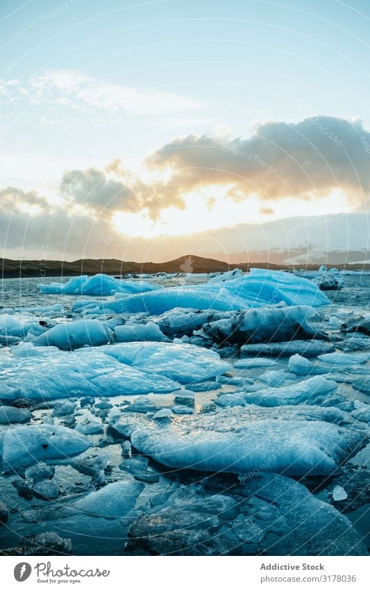 Gebrochene Eisschicht auf dem Wasser mit Bergen Riss Berge u. Gebirge Schnee Winter kalt malerisch Länder Jahreszeiten Landschaft Seeküste schmelzen Frühling