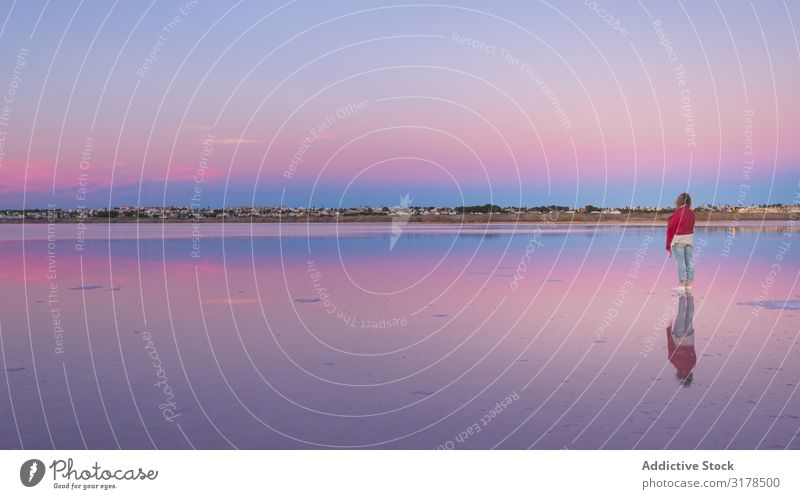 Frau, die den schönen Himmel am leeren Strand bewundert. bewundernd Einsamkeit beobachten ausleeren ruhig Küste rosa blau hell malerisch Meer Natur Landschaft