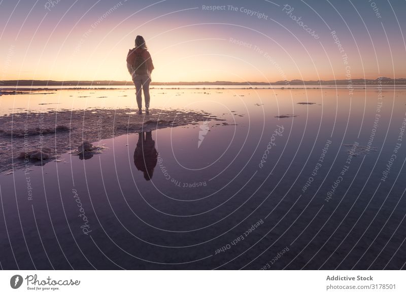 Frau, die den schönen Himmel am leeren Strand bewundert. bewundernd Einsamkeit beobachten ausleeren ruhig Küste rosa blau hell malerisch Meer Natur Landschaft