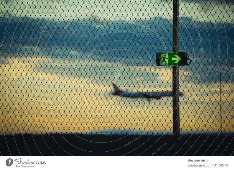 Hinweis - Schild, nach rechts , fliegt das Flugzeug mit ausgeklappten Rädern zu Landebahn. Aufgenommen hinter einem Drahtzaun. Freude Erholung Ausflug Flughafen