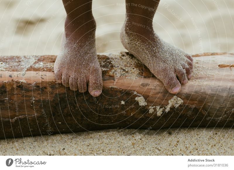 Anonymes schwarzes Kind, das auf einem Baumstamm läuft. Beine laufen Totholz Sand Sommer Strand Barfuß klein nass Lifestyle Freizeit & Hobby ruhen Erholung