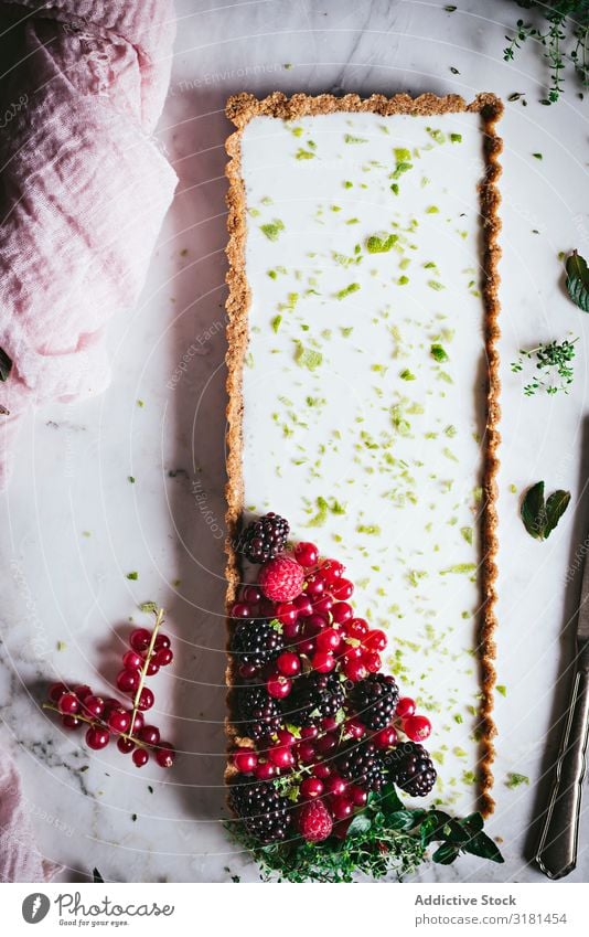 Limettenkuchen mit Beeren dekorierend Kuchen Dessert Lebensmittel süß geschmackvoll gebastelt lecker Tischplatte Himbeeren Stil kulinarisch Stillleben