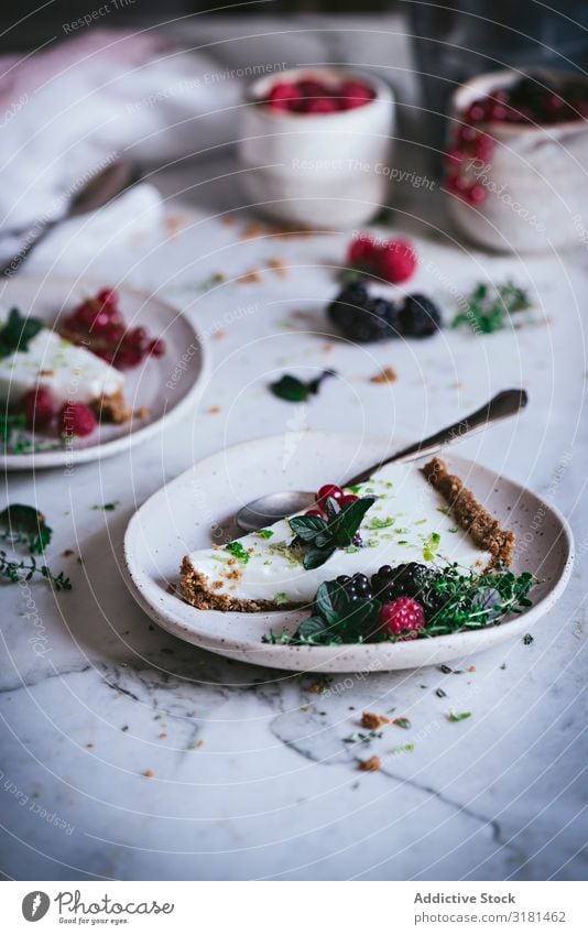 Limettenkuchen mit Beeren dekorierend Kuchen Dessert Lebensmittel süß geschmackvoll gebastelt lecker Tischplatte Himbeeren Stil kulinarisch Stillleben