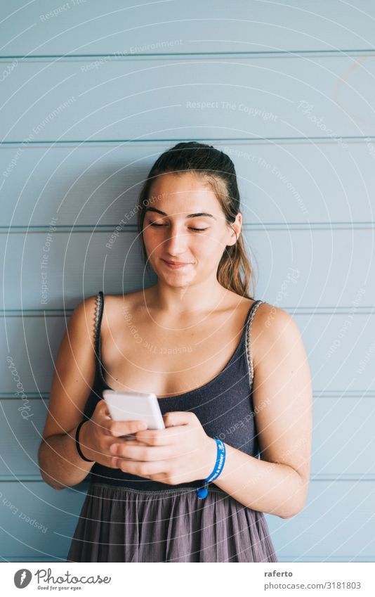 junge Frau, die sich mit dem Smartphone an eine Holzwand lehnt. Lifestyle Glück schön Sommer Telefon Handy PDA Technik & Technologie Mensch feminin Junge Frau