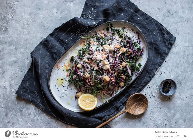 Mohn und Zitrone nahe Gemüsesalat mit Croutons und Parmesan Salatbeilage Saatgut Speise Teller Tisch Löffel serviert Portion Gesundheit Lebensmittel Käse