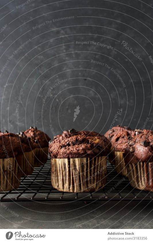 Schokobananen-Muffin auf Handtuch Banane Schokolade Wand grau Lebensmittel Cupcake Dessert frisch lecker geschmackvoll süß Kalorien Snack Backwaren Frühstück