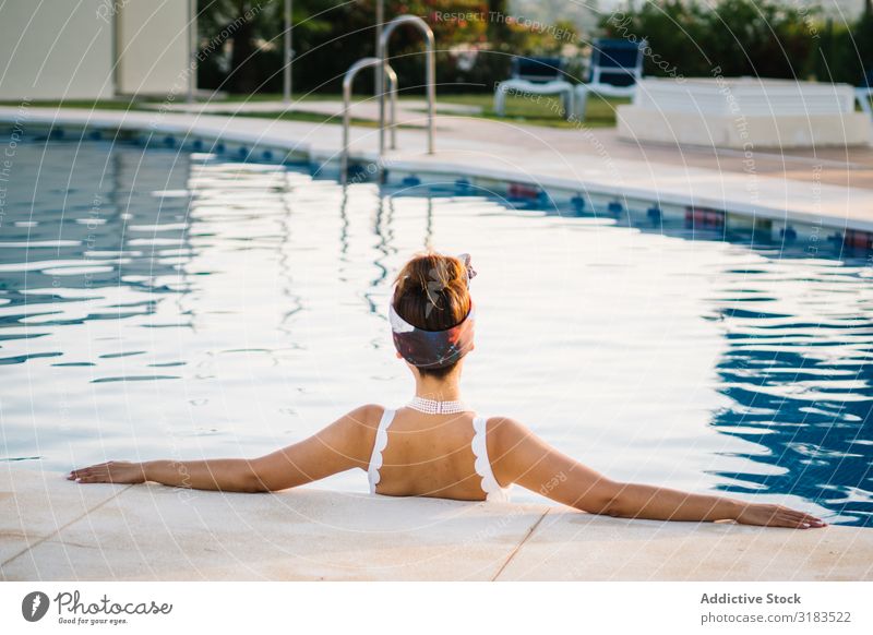 Junge, elegante Chinesin, die sich in einem Pool entspannt. Schwimmbad Chinese Frau wohlhabend Beautyfotografie attraktiv Dame Erwachsene natürlich hübsch