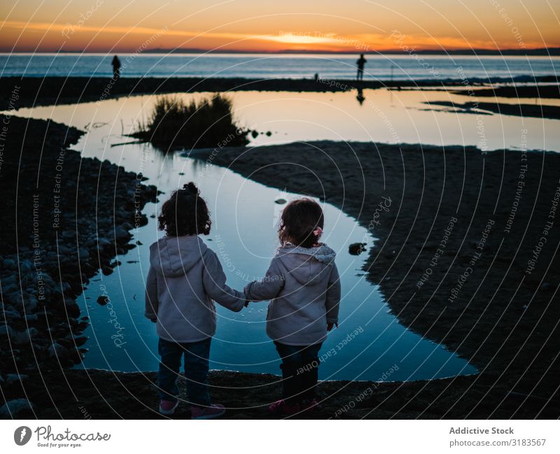 Rückansicht von kleinen Mädchen, die auf das Meer schauen. Kind Küste Fischer Silhouette Sonnenuntergang Ferien & Urlaub & Reisen Mensch niedlich Wasser