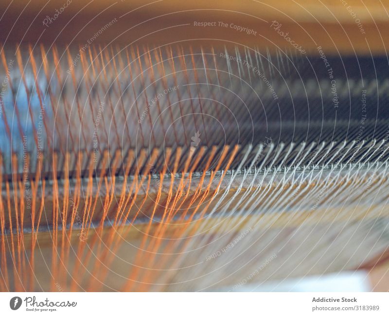 Weiße und orangefarbene Fäden auf dem Webstuhl Faser Industrie Baumwolle Textil Weberei Ballaststoff Stoff Fabrik Schnur Material Maschine Handwerk Tradition