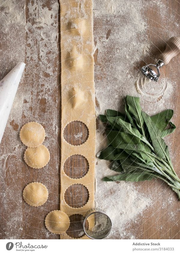 Sauerampfer und Küchengeräte in der Nähe von Ravioli Teigwaren gefüllt Mehl Sauerklee Utensilien Tisch gebastelt Lebensmittel Spätzle Tradition Italienisch