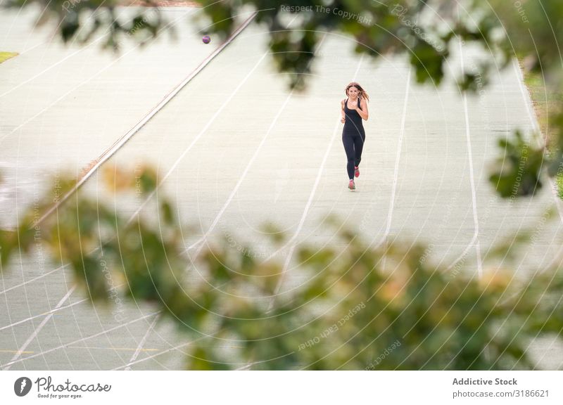 junge, fitte Frau, die an einem sonnigen Tag auf einer Strecke im Freien läuft. rennen Fitness Bahn Stadion Sport üben Herz Joggen Rennsport Aktion Training