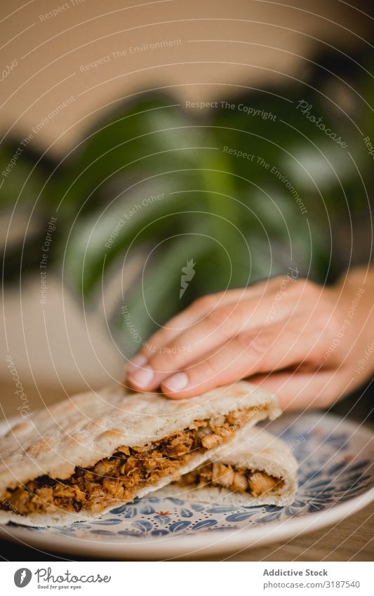 Hand hält heiße, köstliche chinesische Burger in einem asiatischen Restaurant. Lebensmittel Chinese Halt anonym Belegtes Brot Schweinefleisch Zimt gedünstet