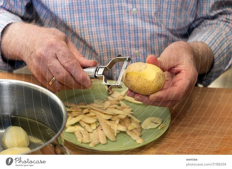 reife Herrenhände schälen Kartoffeln Lebensmittel Gemüse Kartoffelschale Ernährung Mittagessen kochen & garen häuten Teller Topf Messer Sparschäler