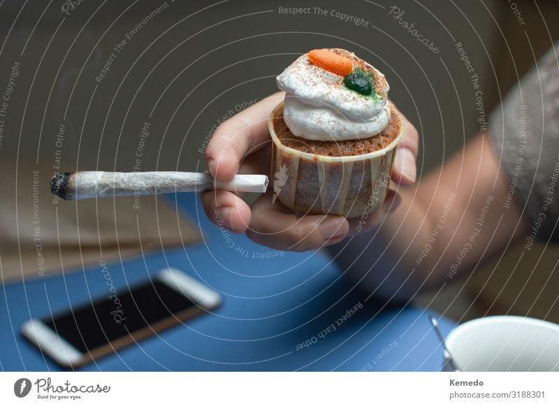 Person, die einen Weltraumkuchen isst und einen großen Marihuana Joint raucht. Lebensmittel Kuchen Dessert Essen Frühstück Heißgetränk Kaffee Topf Lifestyle