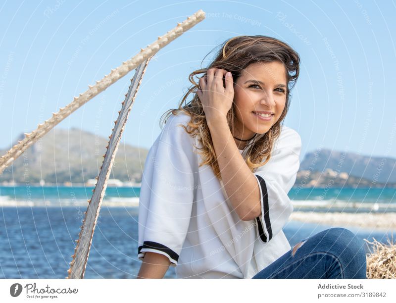 Junge Frau sitzt in der Nähe von getrockneten Pflanzen sitzen Sonnenstrahlen Tag Landschaft ruhen Lifestyle Freizeit & Hobby Erholung harmonisch Idylle