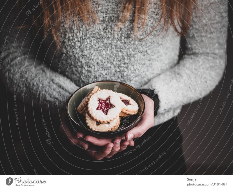 Frau hält Weihnachtskekse in einer Schüssel in ihren Händen Lebensmittel Teigwaren Backwaren Dessert Keks Ernährung Kaffeetrinken Schalen & Schüsseln Lifestyle