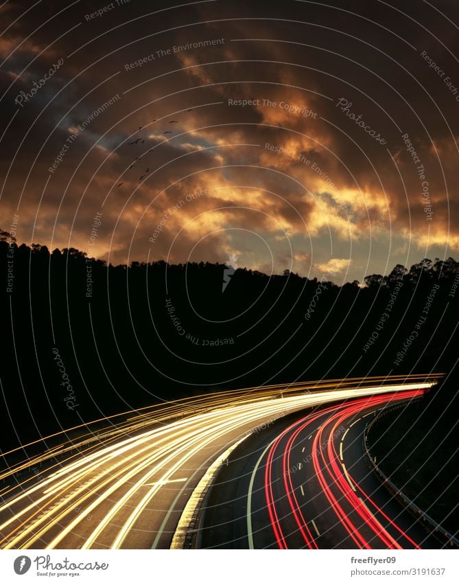 Kurve auf einer Straße mit Lichtspuren der vorbeifahrenden Autos Landschaft Himmel Wolken Hügel Stadtzentrum Hochhaus Gebäude Architektur Verkehr Verkehrswege