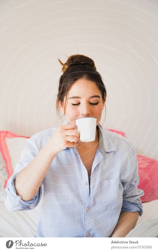 Frau, die mit geschlossenen Augen Kaffee trinkt. Beautyfotografie träumen geschlossene Augen trinken Menschliches Gesicht Energie romantisch Morgen Fürsorge