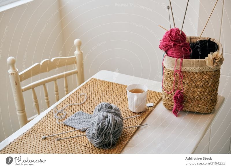 Tasse Tee in der Nähe von Strickmaterial stricken Garn The Needles Tisch gemütlich Raum Korb Freizeit & Hobby Becher Wärme trinken Getränk heiß gebraut Proviant