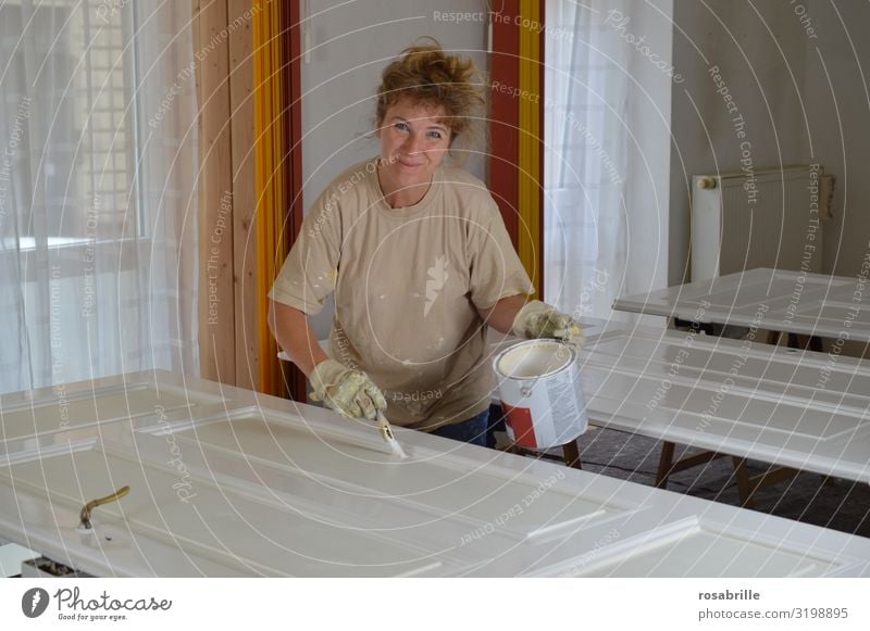 blonde Frau lackiert sorgfältig alte Türblätter mit weißem Lack - do it yourself Freude Freizeit & Hobby Wohnung Renovieren Arbeit & Erwerbstätigkeit Handwerker