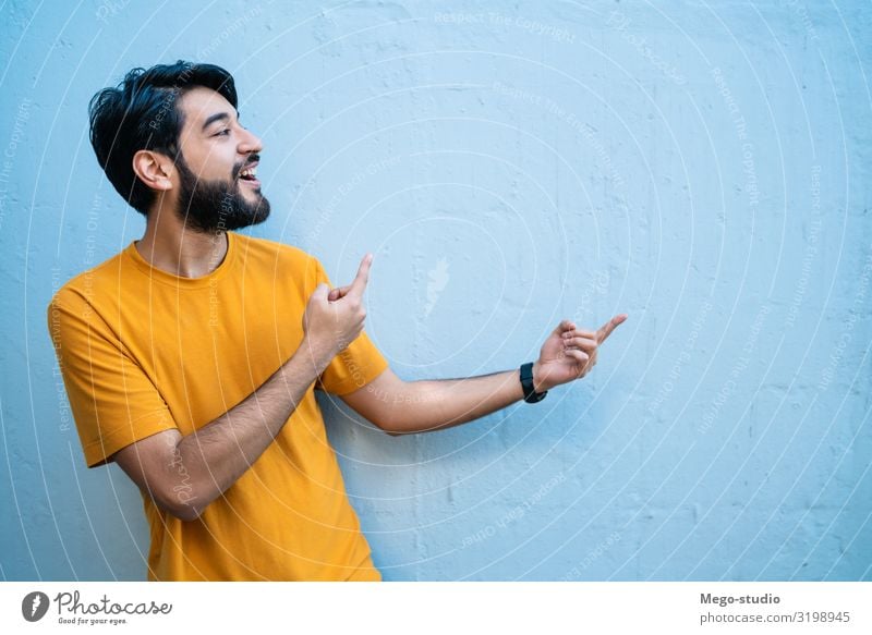 Porträt eines jungen Mannes, der etwas zeigt. Glück schön Mensch Erwachsene Hand Lächeln stehen selbstbewußt Werbung Raum Kopie Hintergrund Menschen vereinzelt