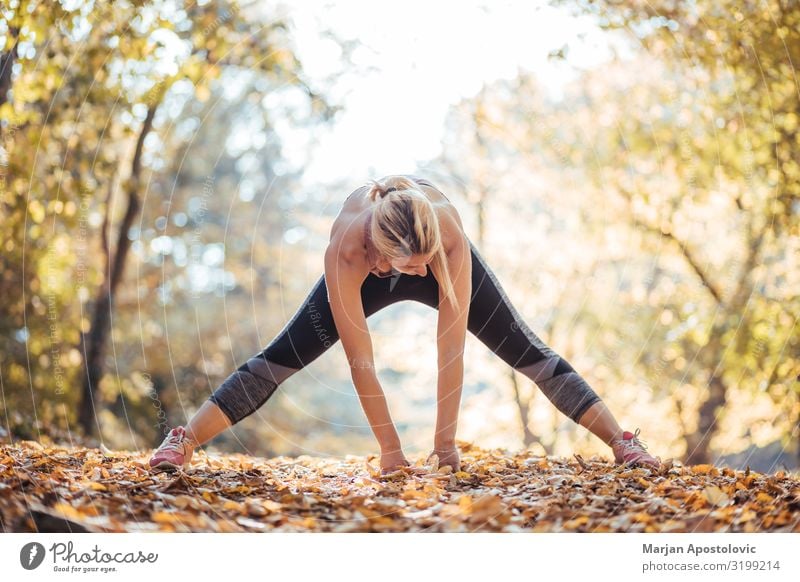 Junge Frau, die sich nach dem Training im Park ausdehnt. Gesundheit sportlich Fitness Wellness Leben Sport Sport-Training Leichtathletik Sportler Joggen feminin