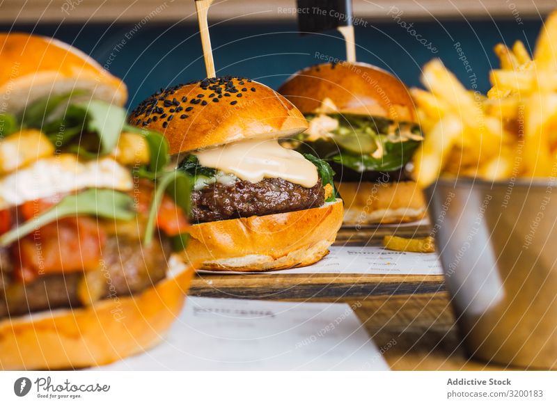 Saftig leckerer Burger und Bratkartoffeln auf dem Tisch Dschunke Essen Hamburger geschmackvoll Kartoffeln Lebensmittel Mahlzeit Rindfleisch Brötchen