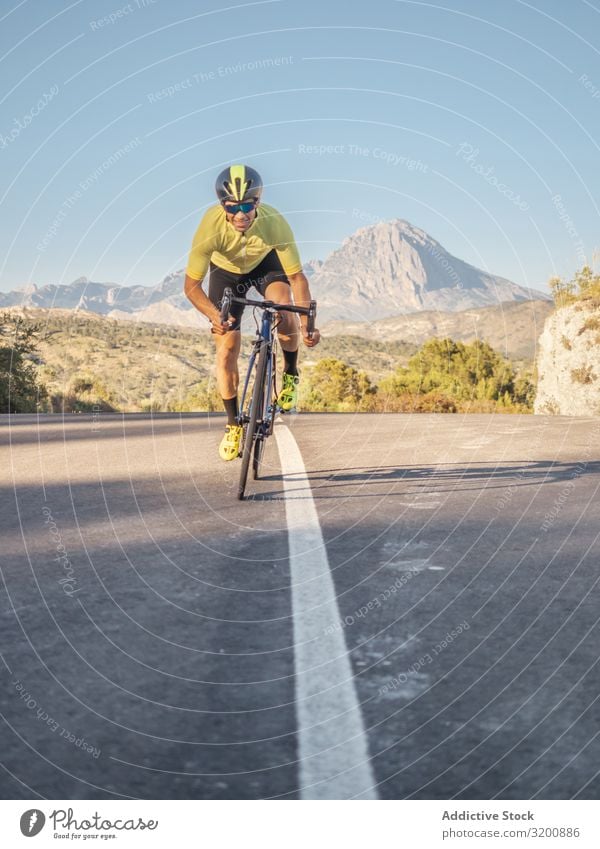 gesunder Mann, der an einem sonnigen Tag auf einer Bergstraße Fahrrad fährt Freizeit & Hobby Athlet Sport Ausritt Rennsport Motorradfahren Außenaufnahme