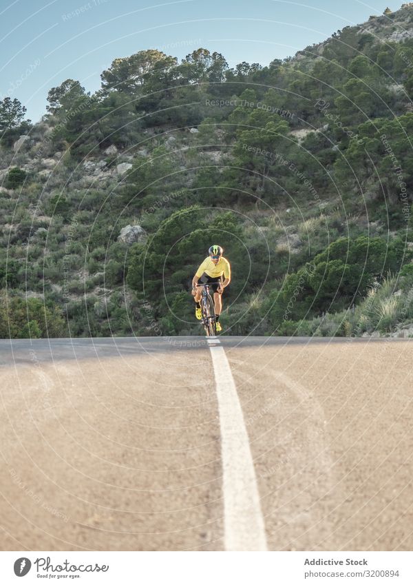 gesunder Mann, der an einem sonnigen Tag auf einer Bergstraße Fahrrad fährt Freizeit & Hobby Athlet Sport Ausritt Rennsport Motorradfahren Außenaufnahme