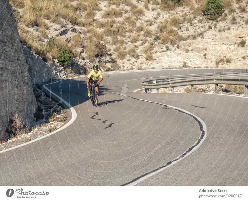 gesunder Mann, der an einem sonnigen Tag auf einer Bergstraße Fahrrad fährt Freizeit & Hobby Athlet Sport Ausritt Rennsport Motorradfahren Außenaufnahme