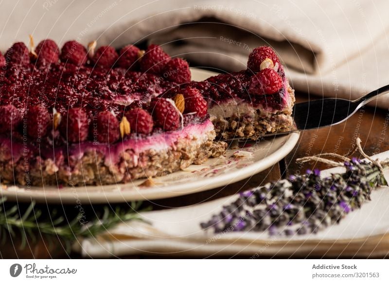 Fruchtbeerkuchen und Lavendelzweig auf dem Tisch Kuchen Vegane Ernährung Himbeeren Lebensmittel Dessert süß frisch rot lecker Beeren gebastelt Backwaren