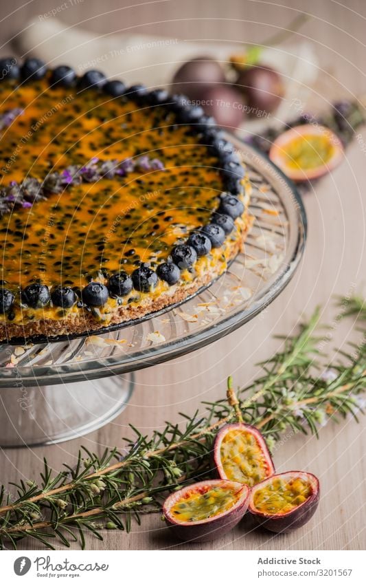 Schmackhafte Passionsfruchttorte mit Heidelbeere dekoriert Pasteten Blaubeeren festlich natürlich Vegane Ernährung Sesam Lebensmittel Dessert frisch lecker Holz