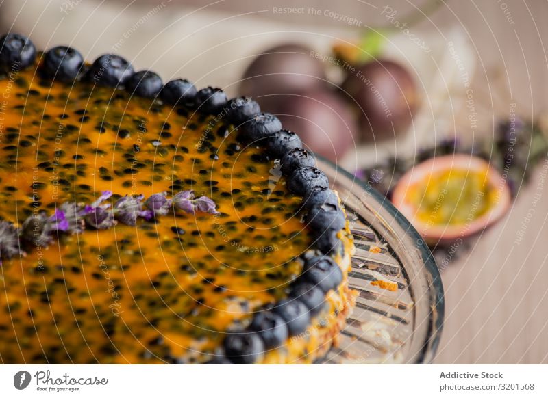 Schmackhafte Passionsfruchttorte mit Heidelbeere dekoriert Pasteten Blaubeeren festlich natürlich Vegane Ernährung Sesam Lebensmittel Dessert frisch lecker Holz